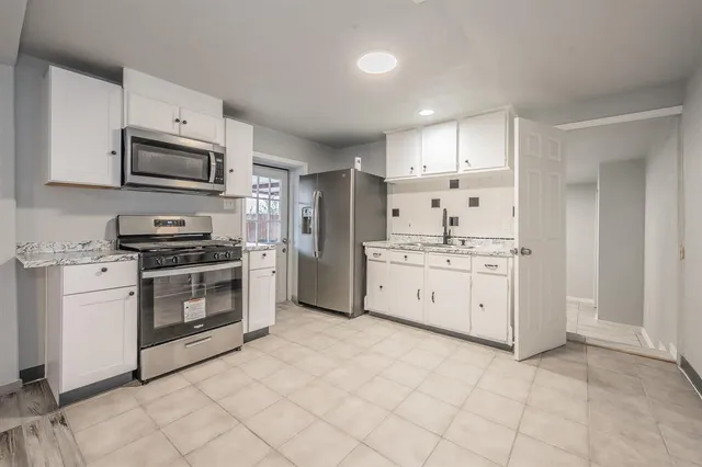 a kitchen with white cabinets stainless steel appliances and sink
