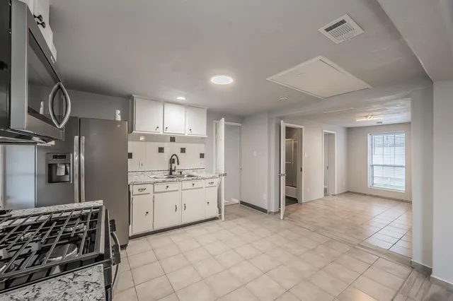 a kitchen with stainless steel appliances granite countertop a refrigerator and a sink