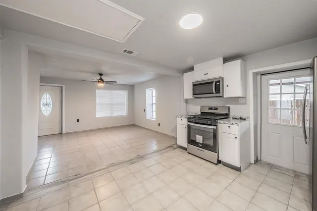 a kitchen with granite countertop a stove top oven and cabinets