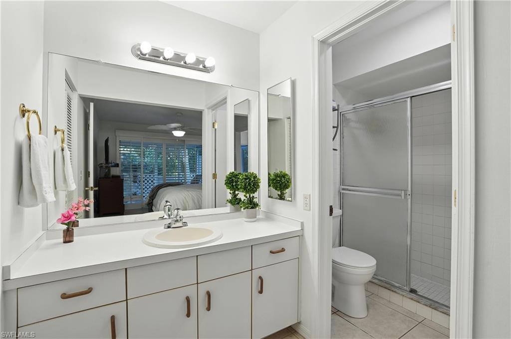 3380 Timberwood Circle Naples, FL 34105 - Photo 16 of 38 a bathroom with a sink vanity granite toilet and a mirror