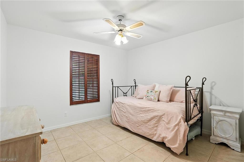 3380 Timberwood Circle Naples, FL 34105 - Photo 21 of 38 a bedroom with a bed and a ceiling fan