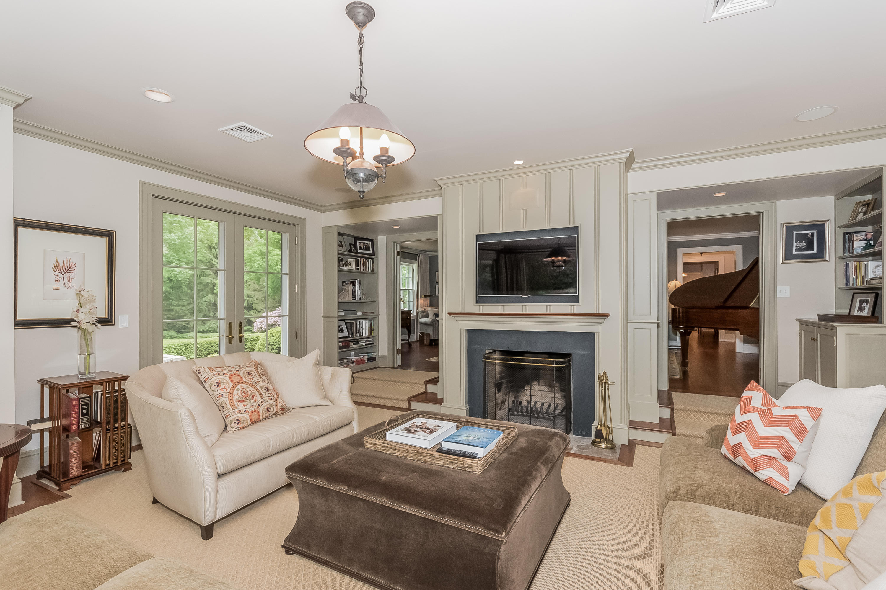 370 Wahackme Road New Canaan, CT 06840 - Photo 9 of 35 a living room with furniture a fireplace and a chandelier