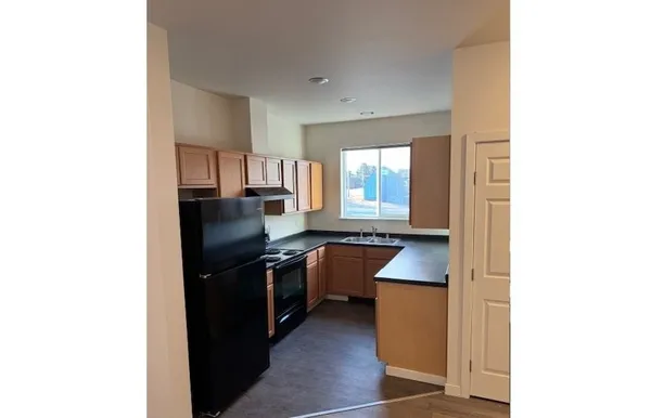 a kitchen with granite countertop a sink stove and refrigerator