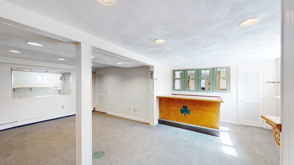 8 Stone Road Arlington, MA 02474 - Photo 17 of 26 an empty room with a fireplace and wooden floor