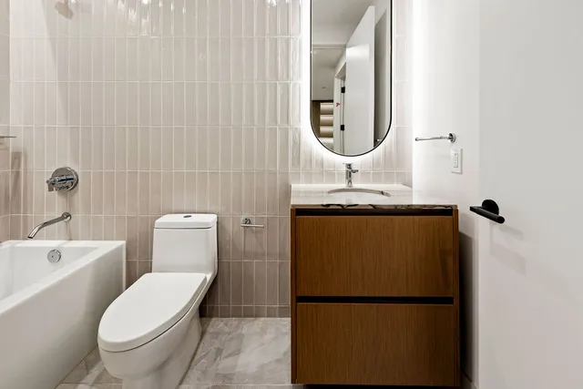 a bathroom with a toilet sink and mirror