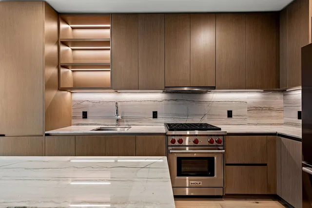 a kitchen with kitchen island granite countertop wooden cabinets and a stainless steel appliances