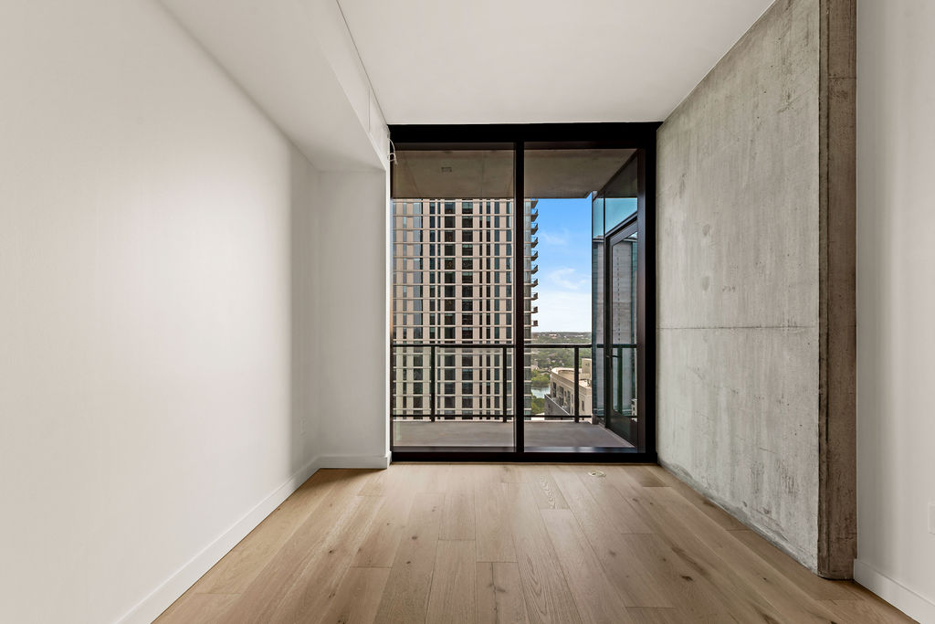 610 Davis Street, Unit 2504 Austin, TX 78701 - Photo 6 of 28 an empty room with wooden floor and windows