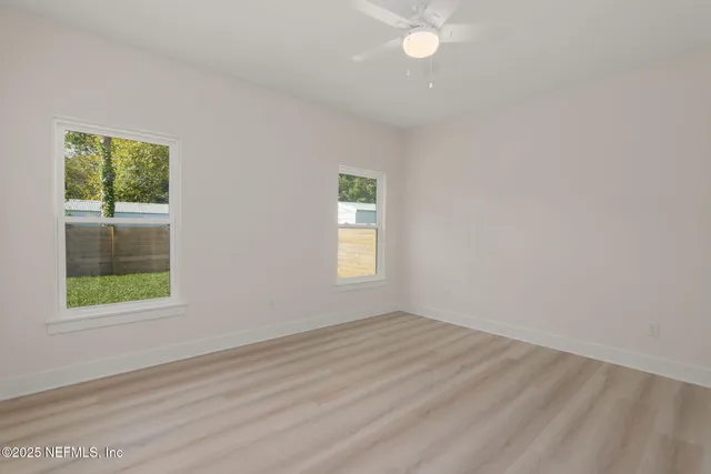 a view of a backyard with potted plants and large tree