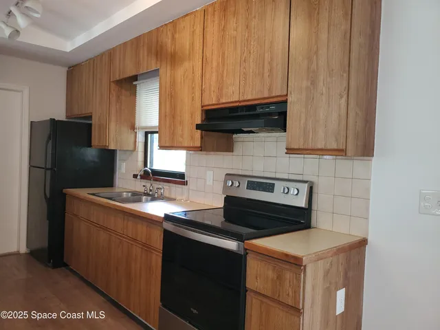 a kitchen with a sink cabinets and refrigerator