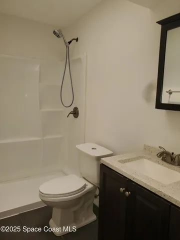 a bathroom with a granite countertop toilet sink and shower