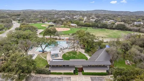 an aerial view of residential houses with outdoor space and trees