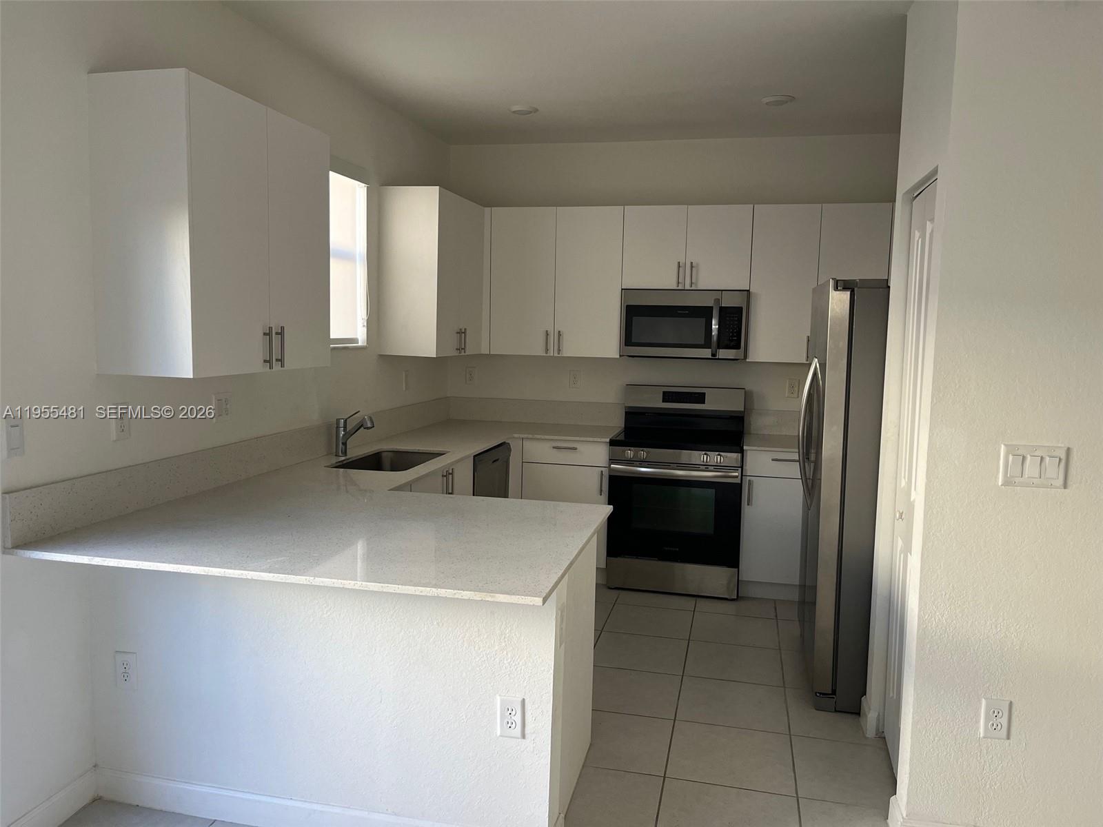 16243 Southwest 289th Street, Unit 16243 Homestead, FL 33033 - Photo 6 of 12 a kitchen with a sink and steel appliances
