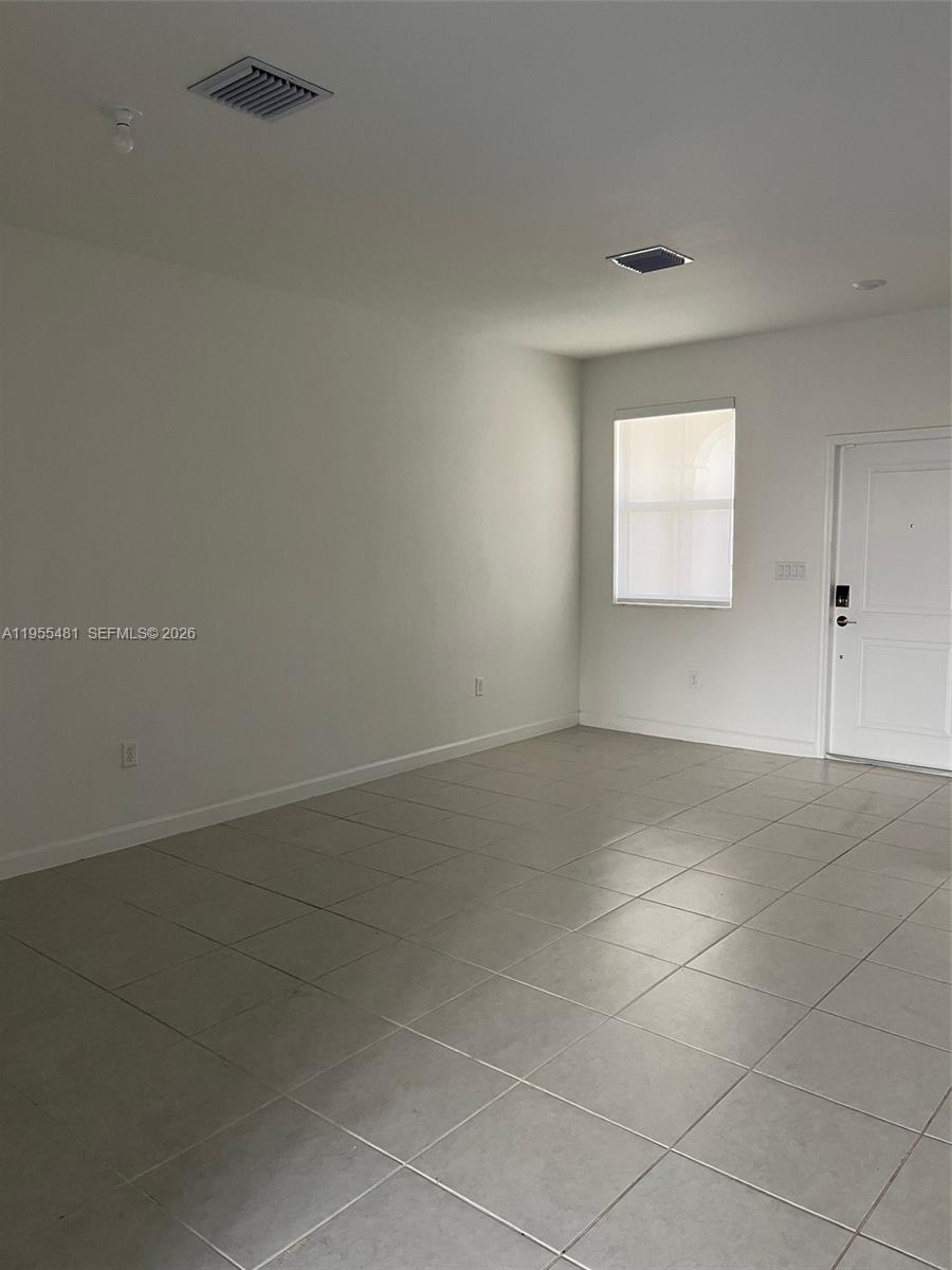16243 Southwest 289th Street, Unit 16243 Homestead, FL 33033 - Photo 8 of 12 an empty room with a empty space and windows