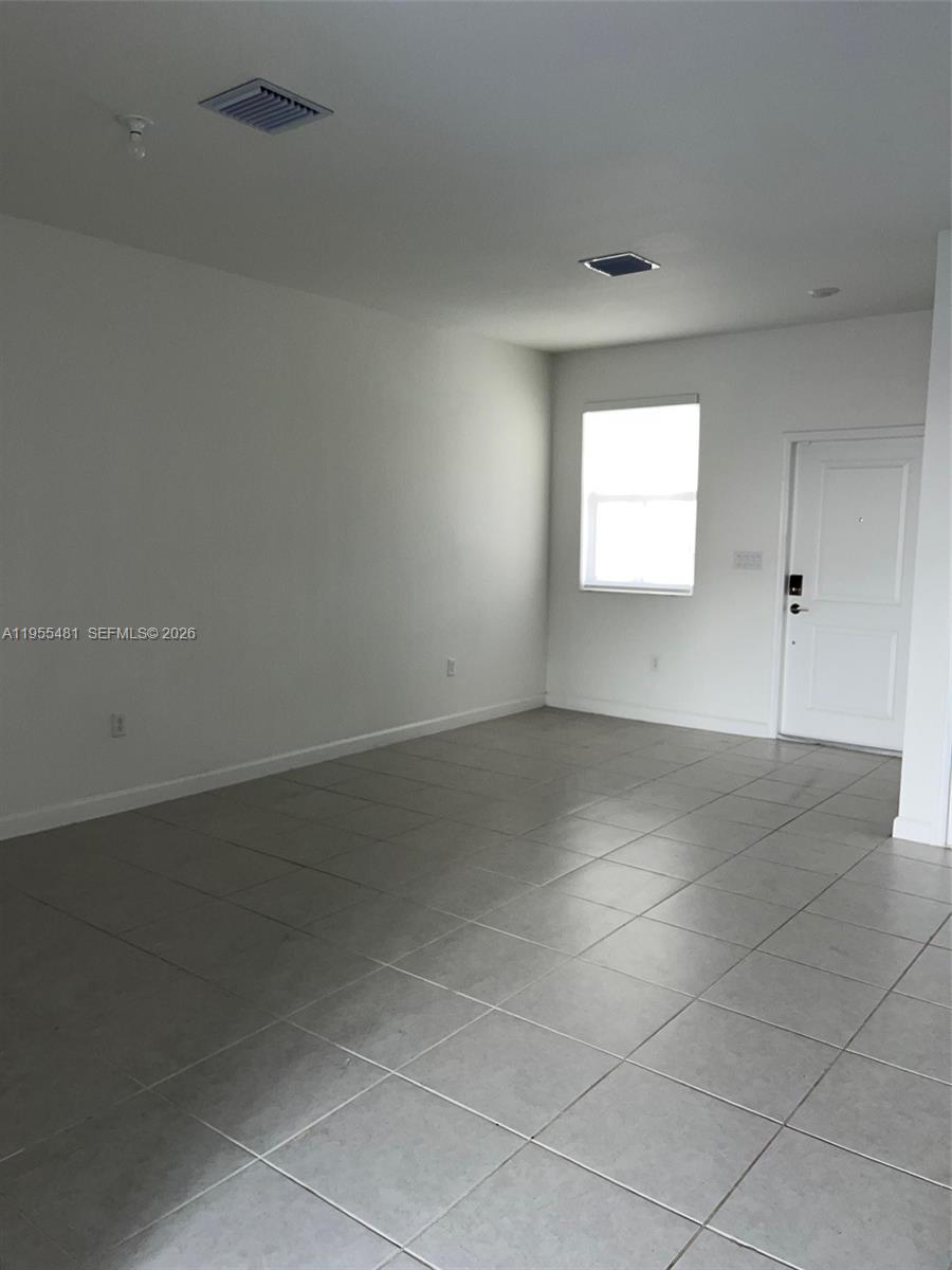 16243 Southwest 289th Street, Unit 16243 Homestead, FL 33033 - Photo 9 of 12 an empty room with a empty space and windows