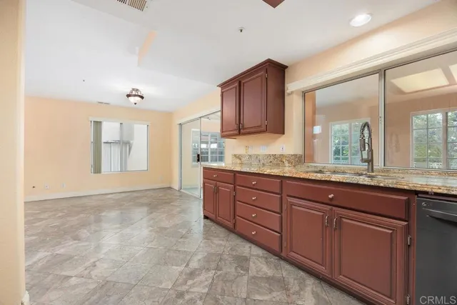 a bathroom with a granite countertop sink and a large mirror