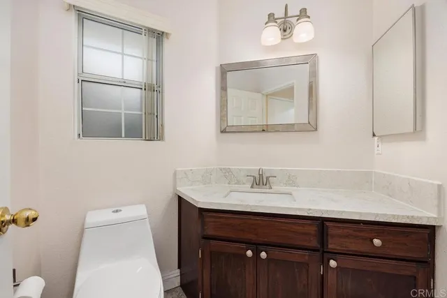 a bathroom with a sink vanity and toilet