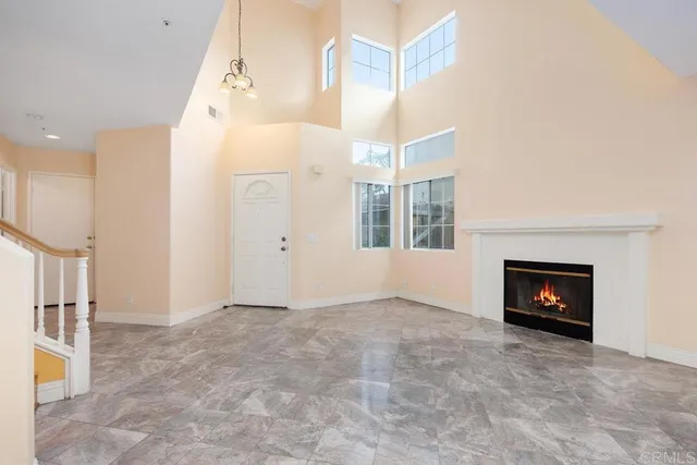 an empty room with windows and fireplace