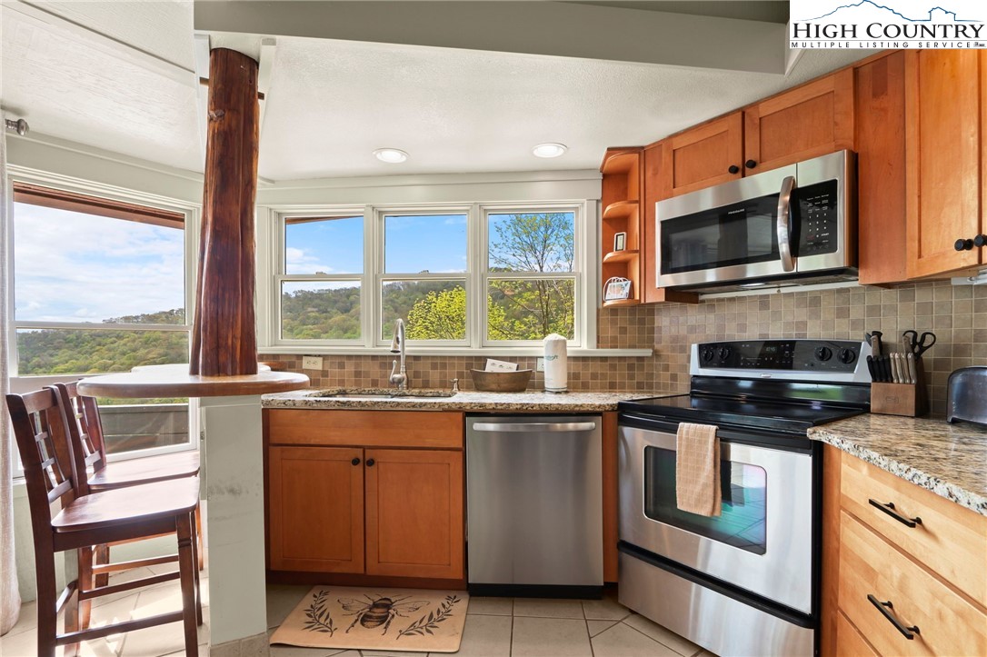 104 Longview Court Seven Devils, NC 28604 - Photo 13 of 46 a kitchen with stainless steel appliances a stove a sink and a microwave