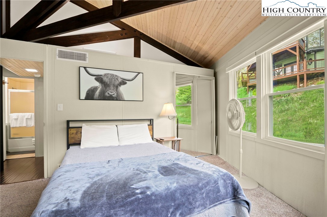 104 Longview Court Seven Devils, NC 28604 - Photo 16 of 46 a bedroom with a large bed and a window