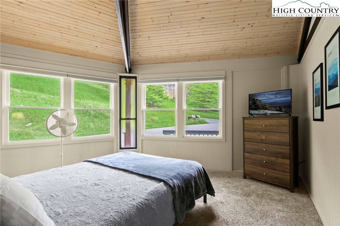 104 Longview Court Seven Devils, NC 28604 - Photo 21 of 46 a bedroom with a bed dresser and a large window