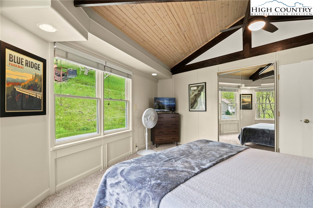 104 Longview Court Seven Devils, NC 28604 - Photo 23 of 46 a bedroom with a bed and a large window with outer view