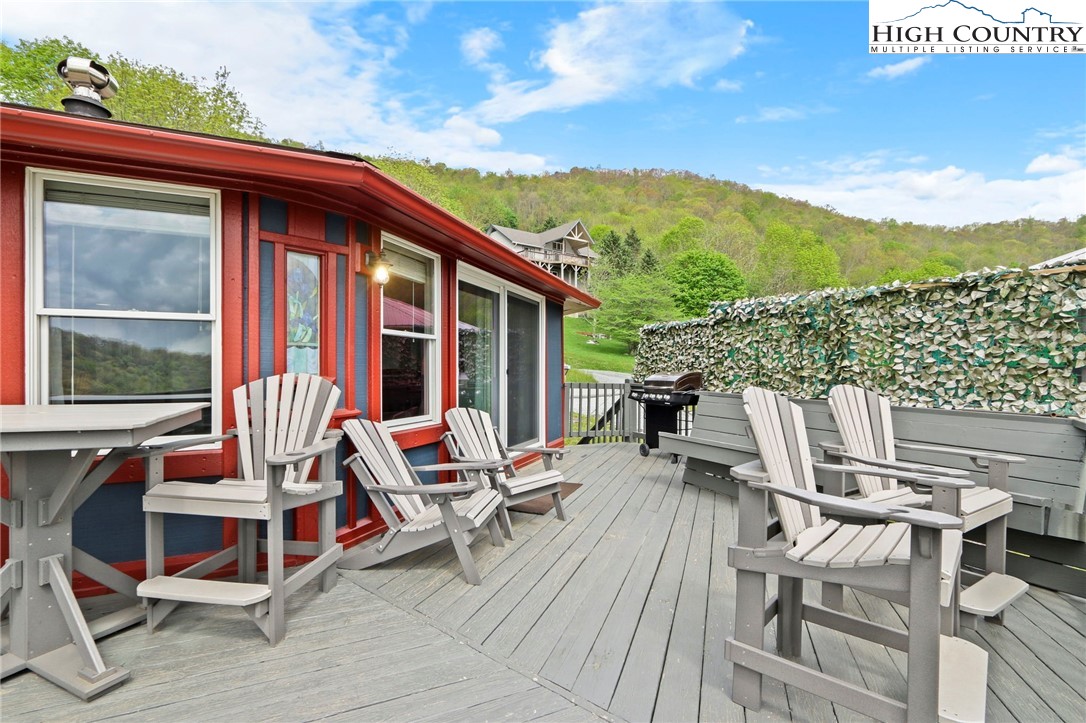 104 Longview Court Seven Devils, NC 28604 - Photo 32 of 46 a view of a patio with a dining table and chairs with wooden floor