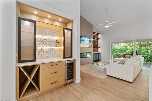 a living room with furniture a large window and wooden floors