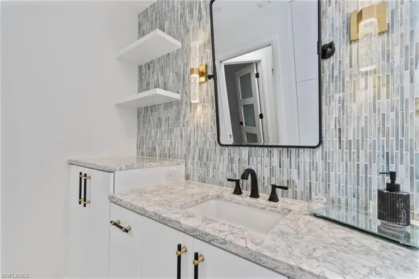 a bathroom with a granite countertop sink and a mirror