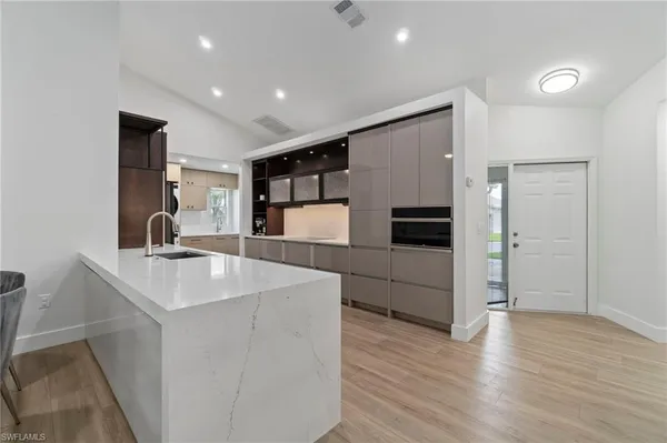 a kitchen with stainless steel appliances kitchen island a sink and a refrigerator