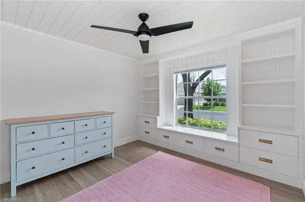 a bedroom with a large bed chandelier and a window