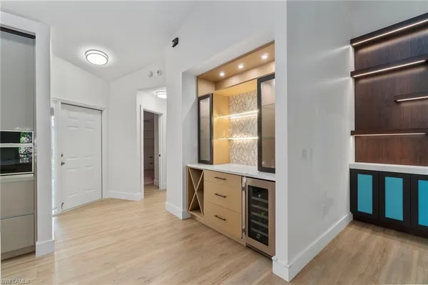 a view of a hallway with wooden floor and cabinet