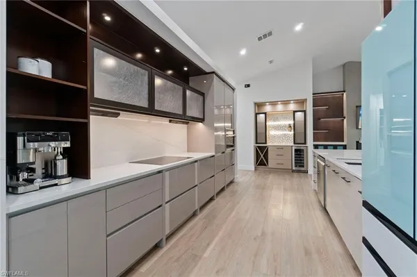 a large kitchen with stainless steel appliances a large counter top a stove and a refrigerator