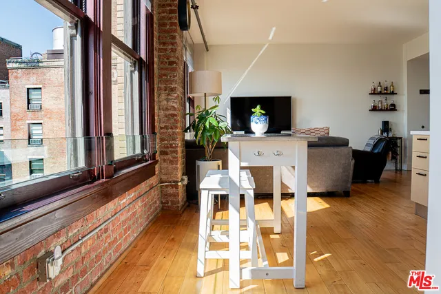 a living room with furniture a flat screen tv and a floor to ceiling window