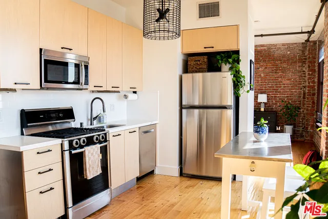 a kitchen with stainless steel appliances white cabinets and a stove top oven