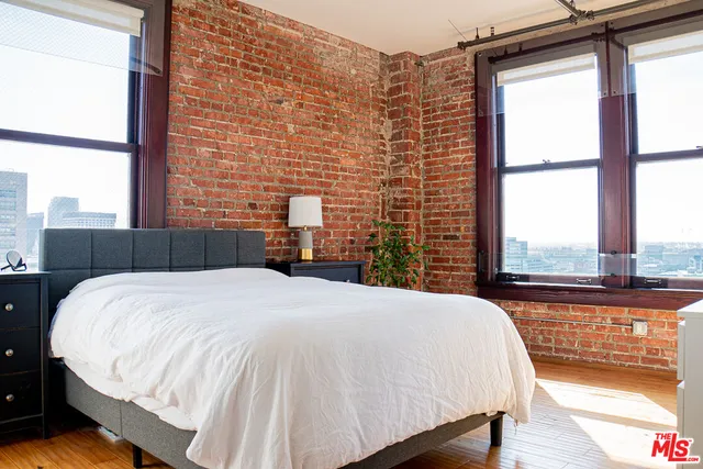 a bedroom with a bed and a large window