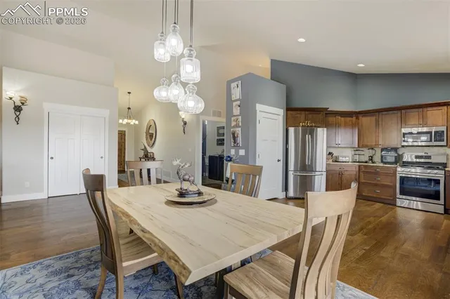 a view of a dining room and livingroom with furniture wooden floor a rug a chandelier