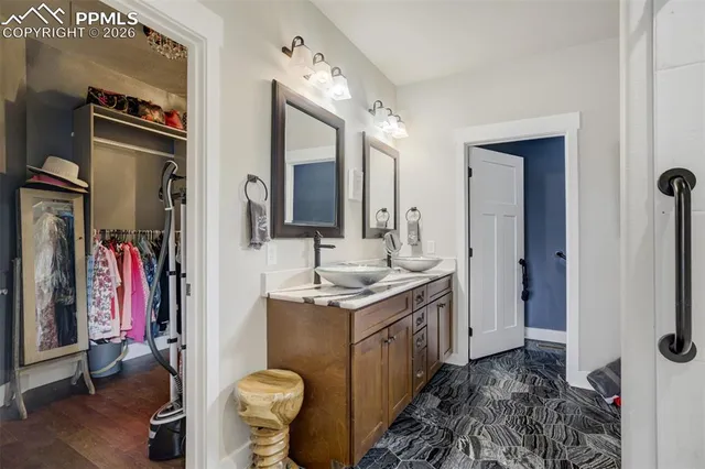 a bathroom with a granite countertop sink and a mirror