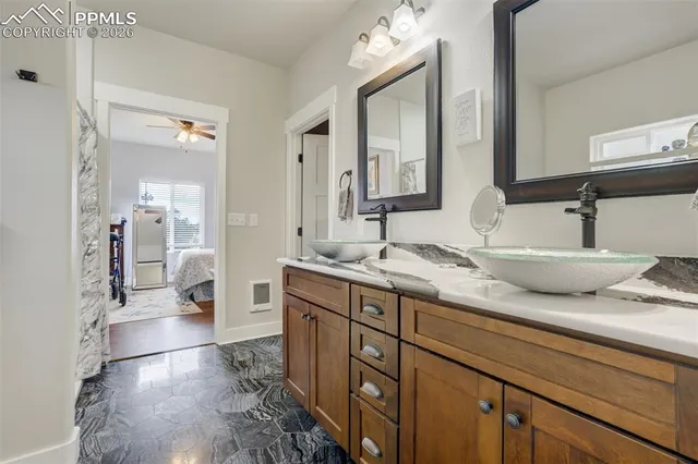 a spacious bathroom with a granite countertop sink and a mirror