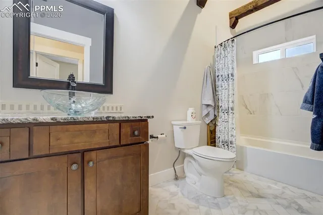 a bathroom with a granite countertop sink toilet mirror and a bathtub
