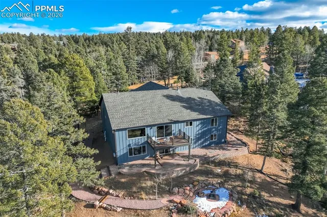a patio with table and chairs and potted plants