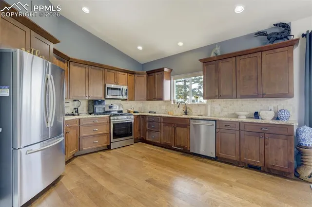 a kitchen with granite countertop stainless steel appliances a refrigerator sink and microwave