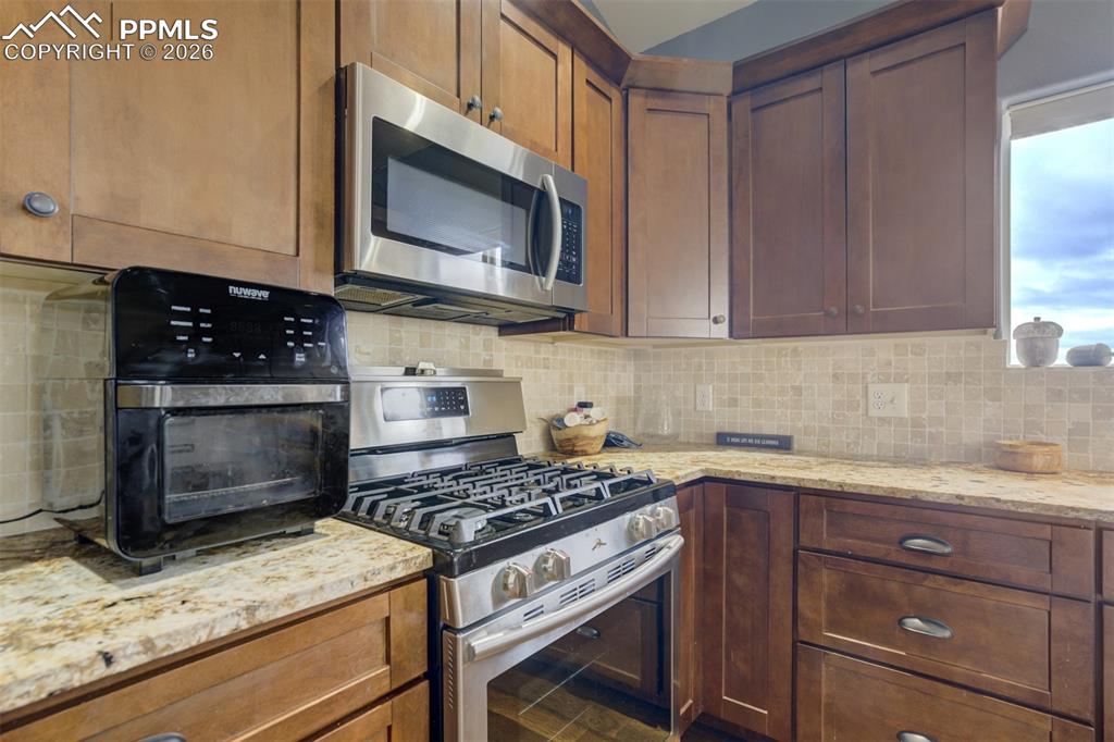 57 Cradle Lake Place Divide, CO 80814 - Photo 10 of 48 a kitchen with granite countertop wooden cabinets and a stove top oven