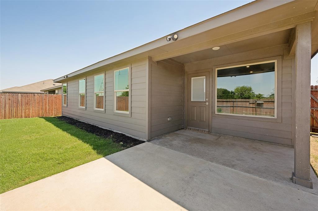 857 Watson Way Crowley, TX 76036 - Photo 24 of 25 Covered concrete patio with recessed lighting and a single panel door, featuring a large window, horizontal siding, and a wooden privacy fence