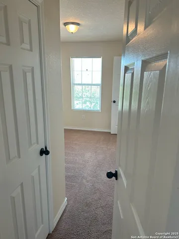 a view of a hallway with closet and wooden floor