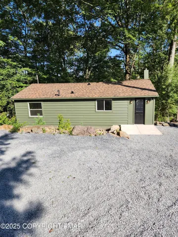 a view of backyard of house and car parked