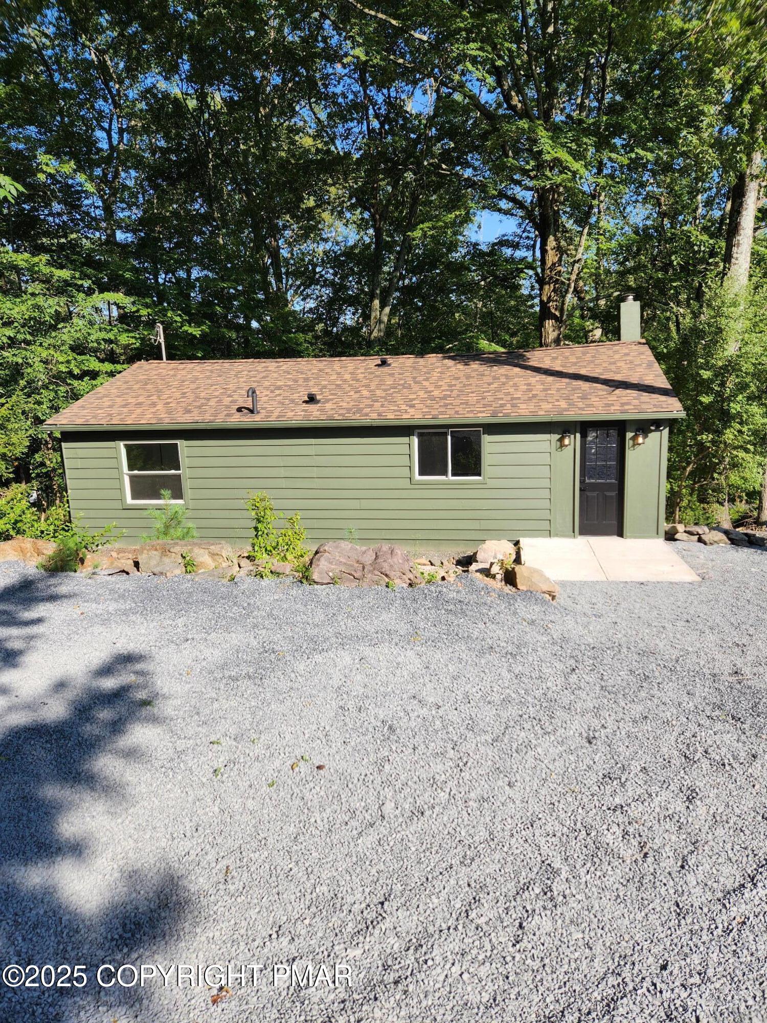 a view of backyard of house and car parked