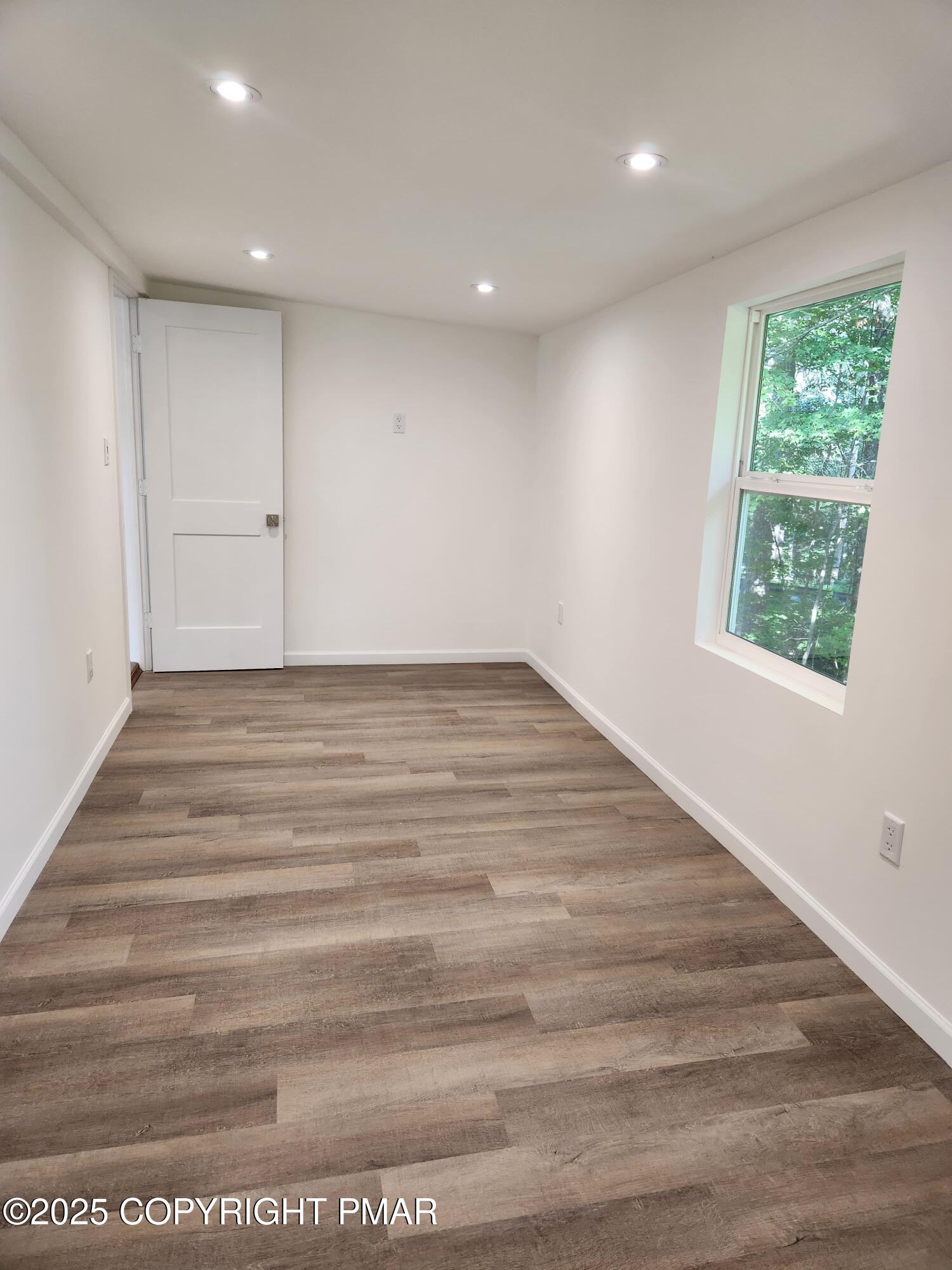 386 Hunters Farm Road Henryville, PA 18332 - Photo 13 of 18 a view of an empty room with wooden floor and a window