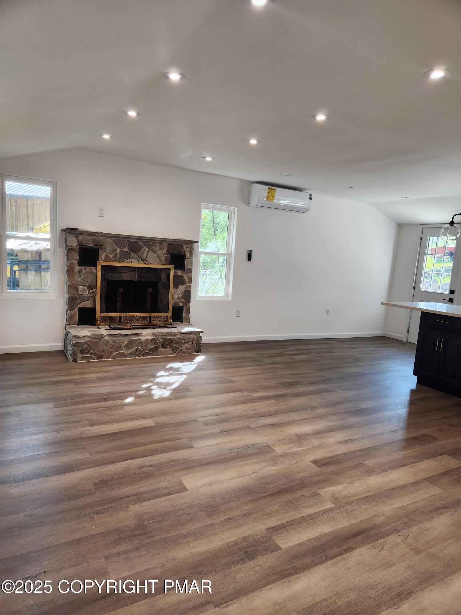 386 Hunters Farm Road Henryville, PA 18332 - Photo 8 of 18 an empty room with wooden floor fireplace and windows