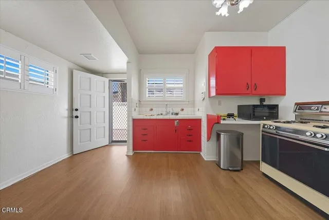 a kitchen with granite countertop a stove top oven sink and cabinets