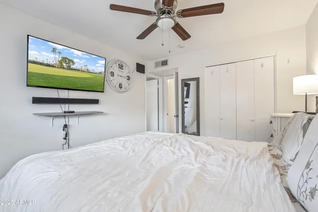a bedroom with a bed and a flat screen tv